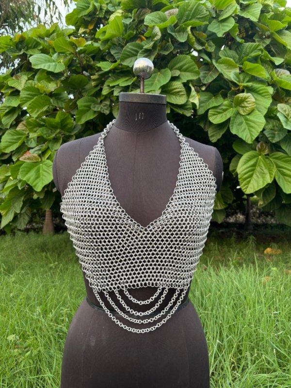 Chainmail halter top for women displayed on a dress form, handmade metal fashion armor top with draped chains.