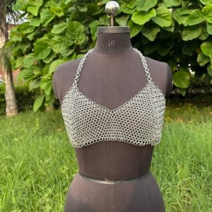 Handmade chainmail crop top bra on a dress form, minimalist medieval armor design for cosplay, festival, or alternative fashion.