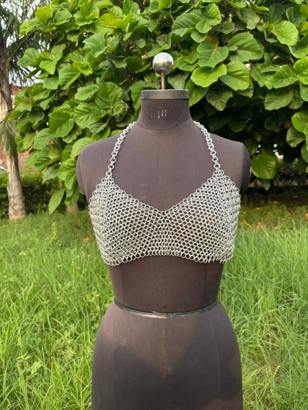 Handmade chainmail crop top bra on a dress form, minimalist medieval armor design for cosplay, festival, or alternative fashion.