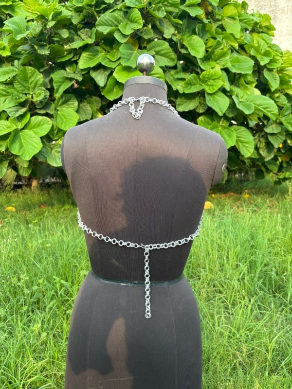 Handmade chainmail crop top bra on a dress form, minimalist medieval armor design for cosplay, festival, or alternative fashion.